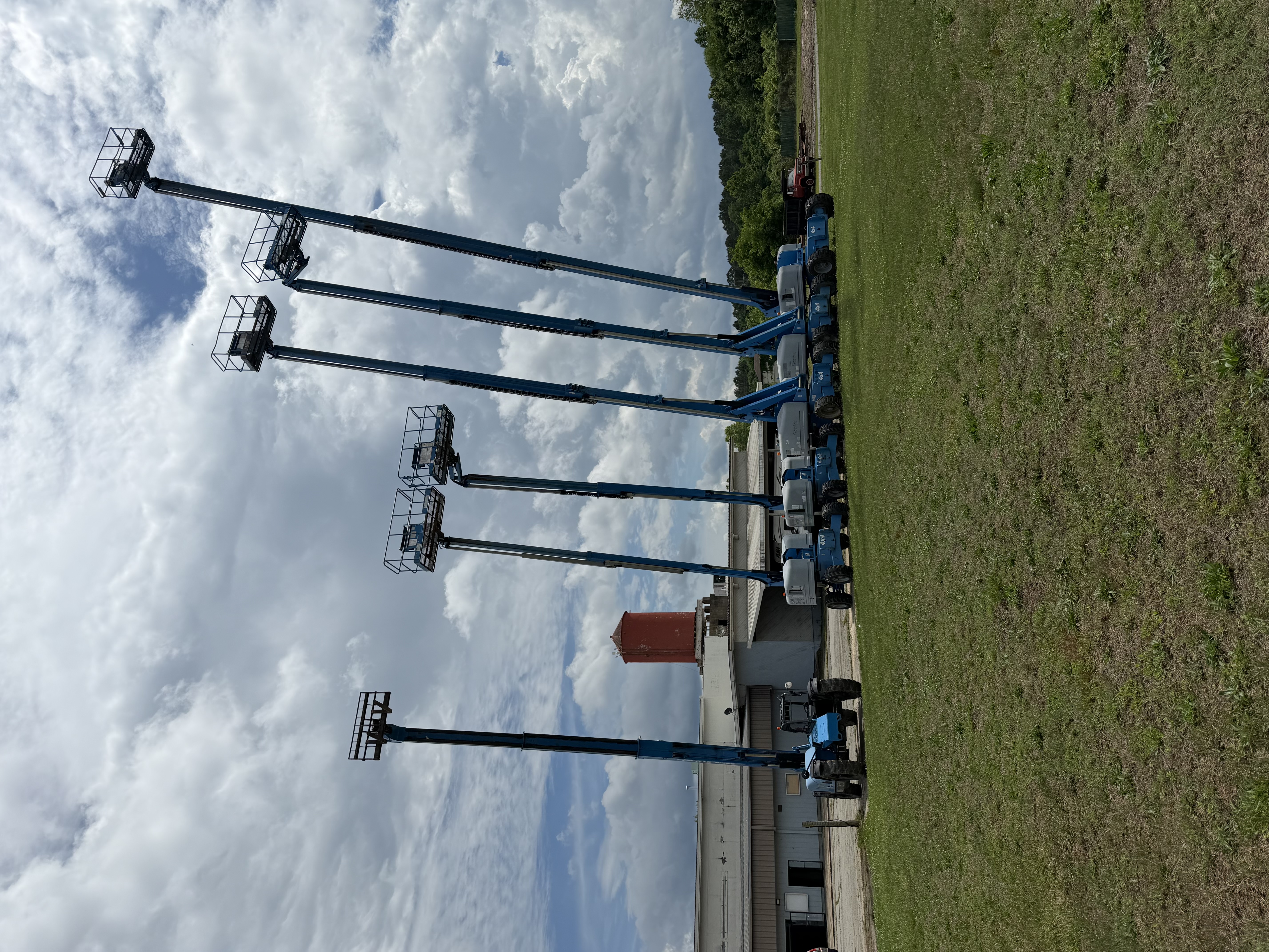 Genie 4x4 boom lifts fully extended on the 58 Equipment Rentals yard